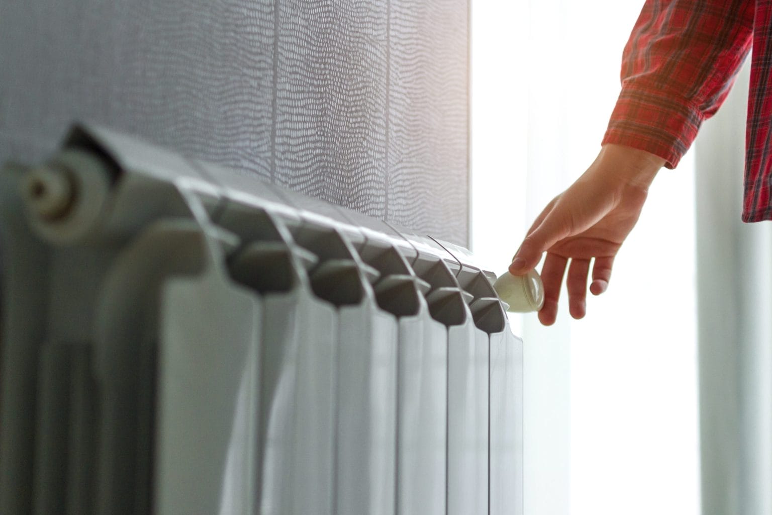 Person Adjusting Radiator for Heater Service and Repair
