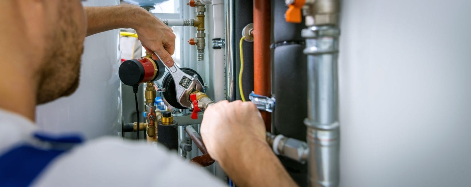 Plumber Fixing HVAC System Pipes
