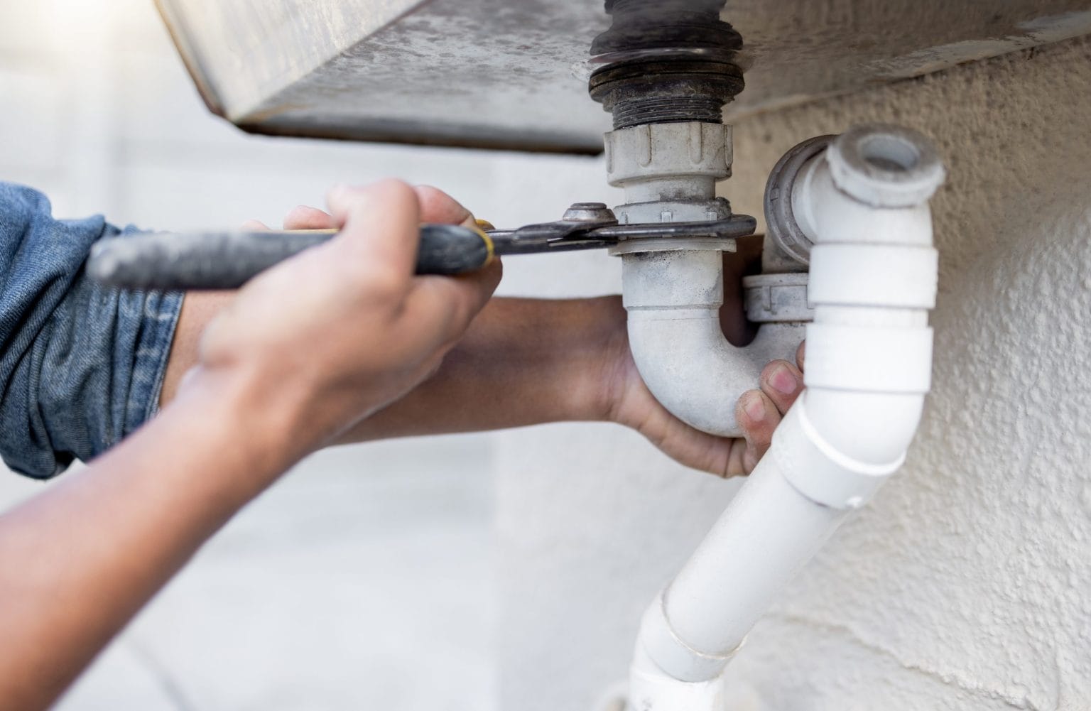 Plumber Performing Leak Repairs on a Pipe
